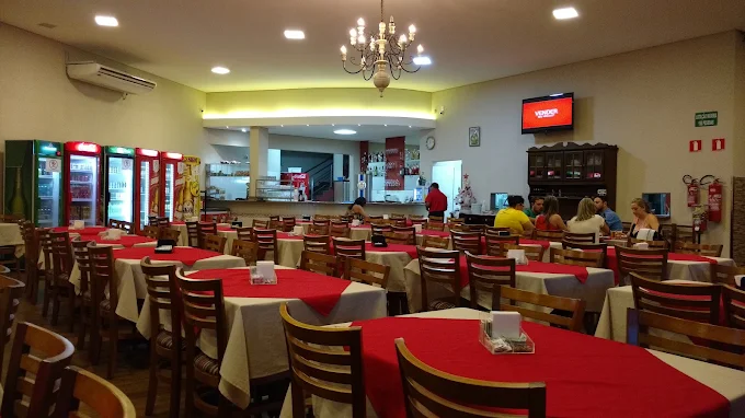Salão amplo do Restaurante Recanto com mesas decoradas em vermelho e branco